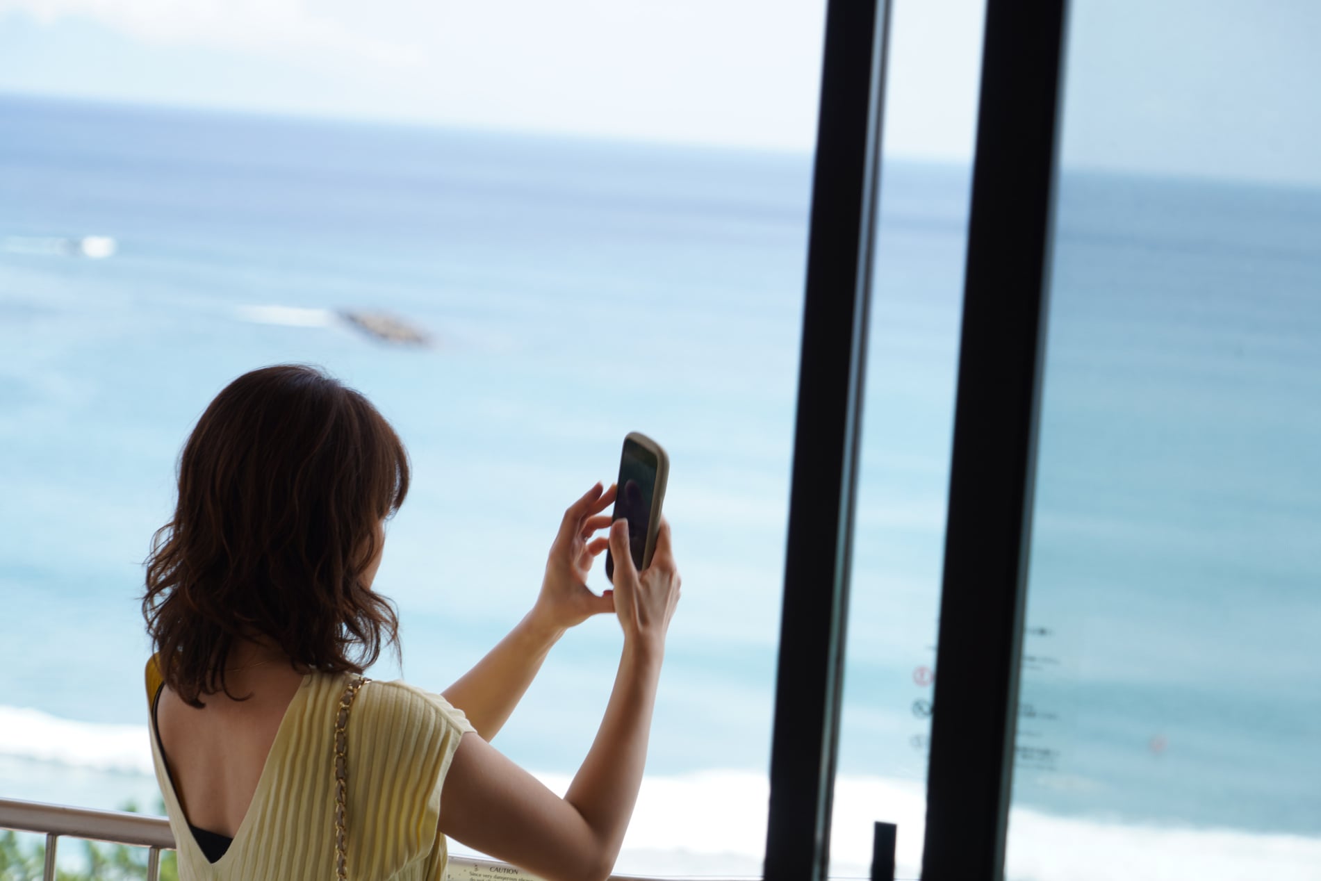 海を眺めながらスマートフォンで撮影